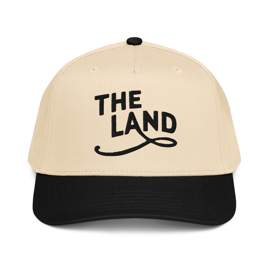 Beige and black cap with 'THE LAND' text on a white background