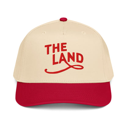 Beige and red cap with 'THE LAND' text on a white background