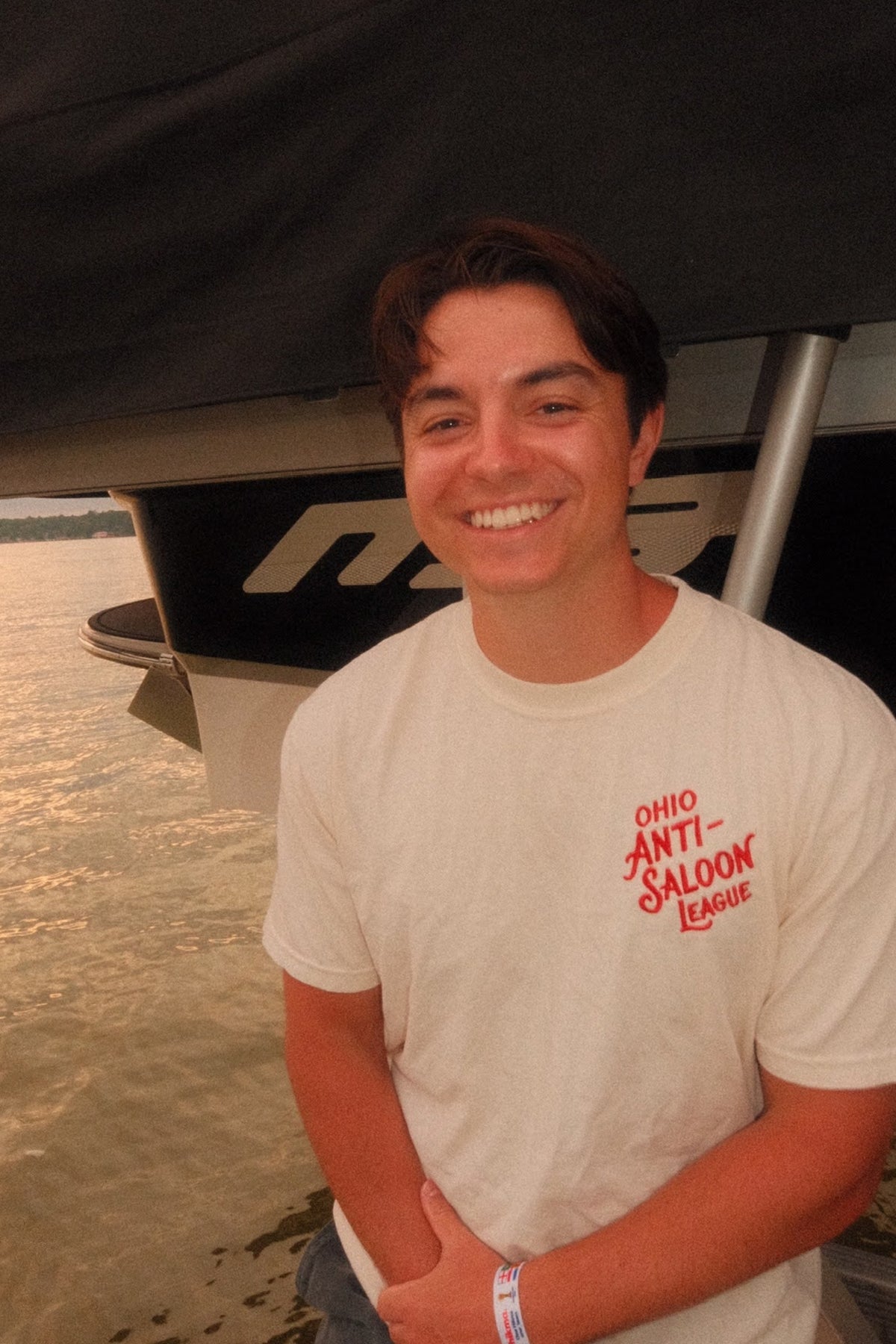 Ivory Ohio Anti-Saloon League Tablespoon heavyweight t-shirt worn on a dock, front graphic reading Ohio Anti-Saloon League