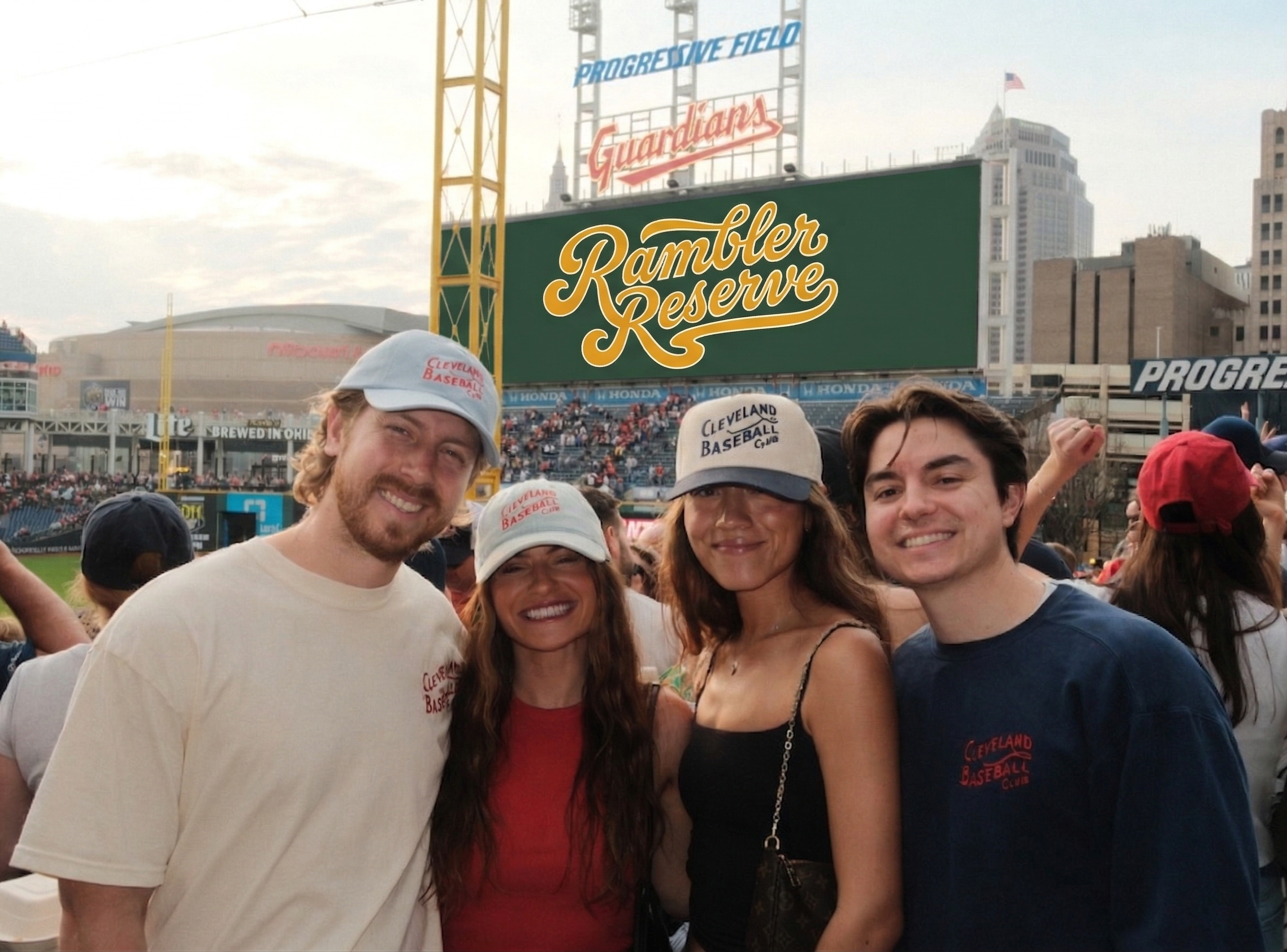 Group of people at a baseball game with a 'Rambler Reserve' sign in the background.
